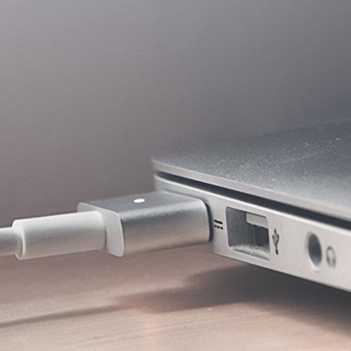 Imagem de um cabo de energia conectado a um laptop